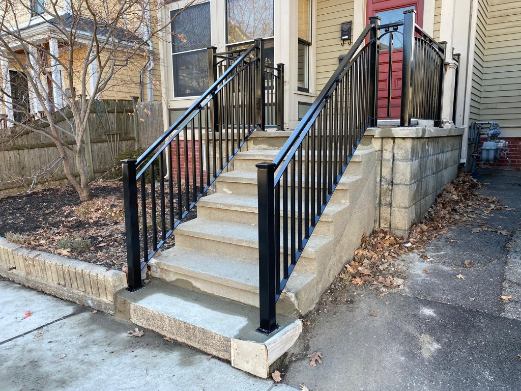 Custom black iron railings on residential concrete steps, Ironworks Network