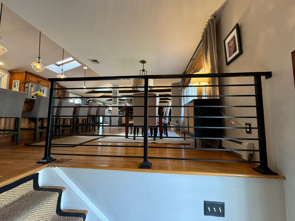 Loft railing with horizontal bars overlooking a dining room, Ironworks Network