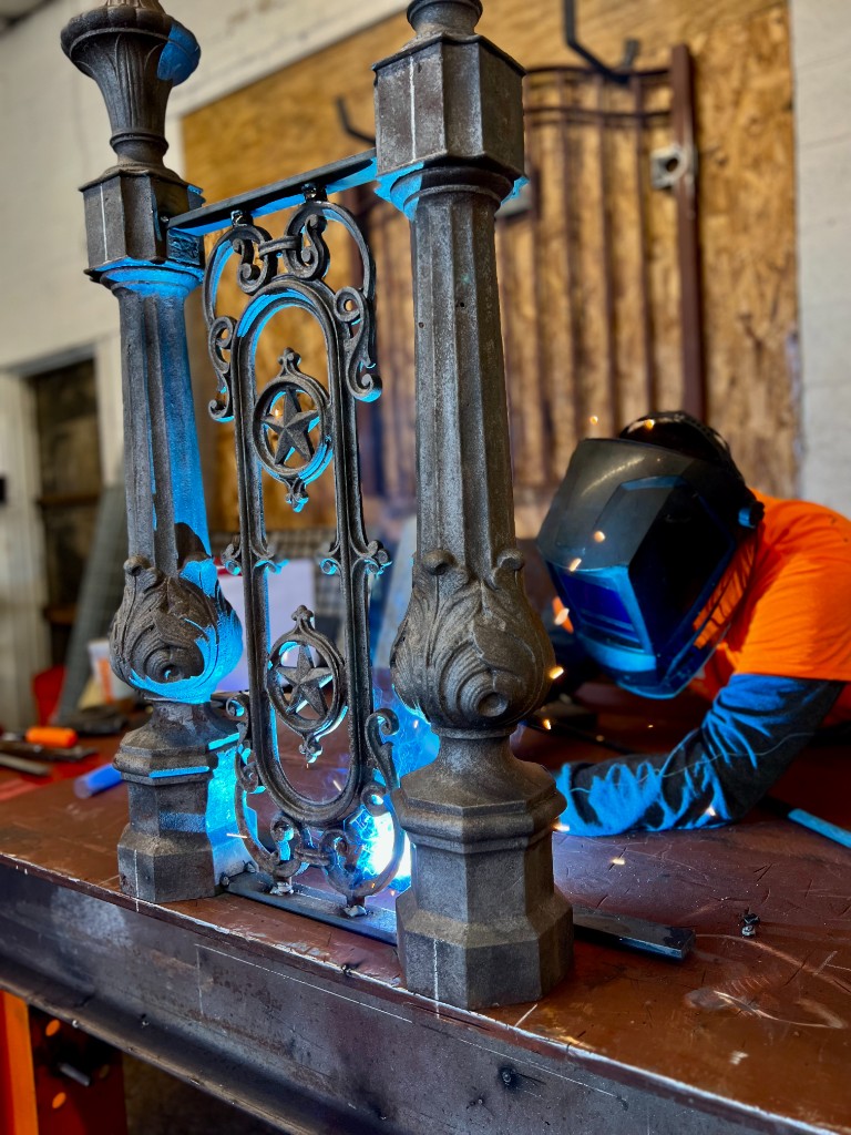 Historic ornamental iron railing during in-shop welding repair, specialty restoration